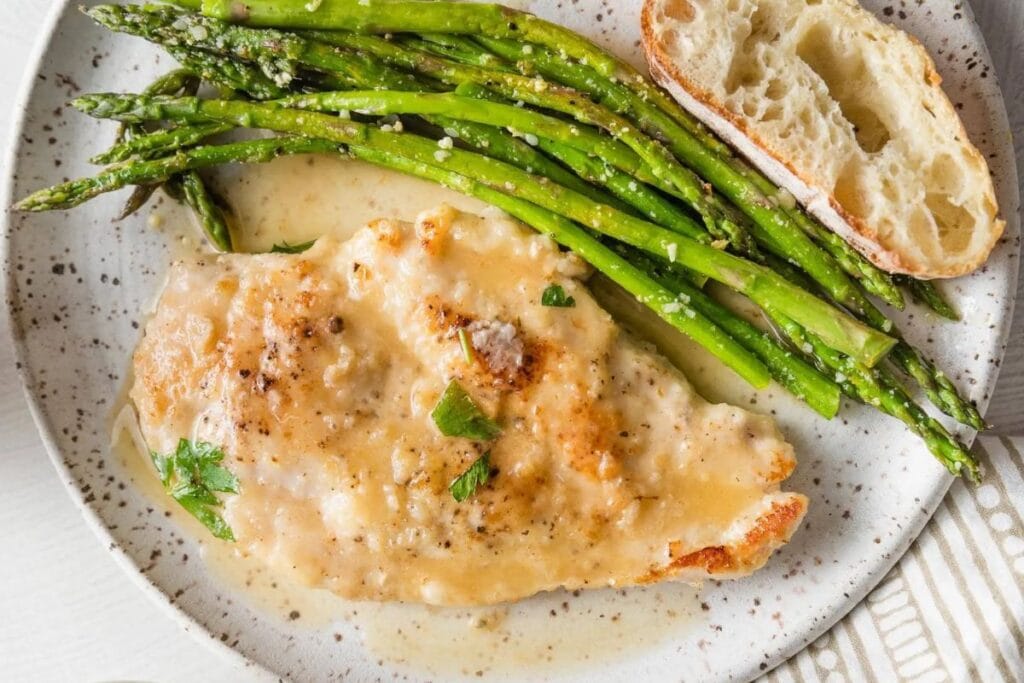 Chicken and asparagus on a plate.