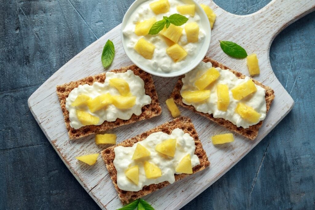 Cottage cheese and pineapple on a wooden board.