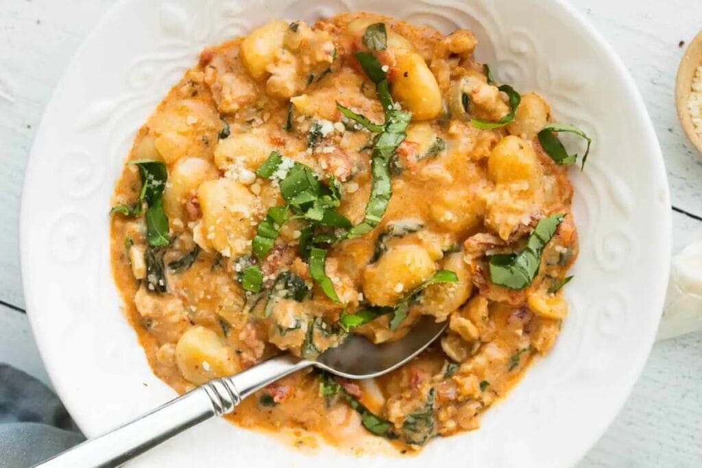 Creamy gnocchi and sausage in a bowl.