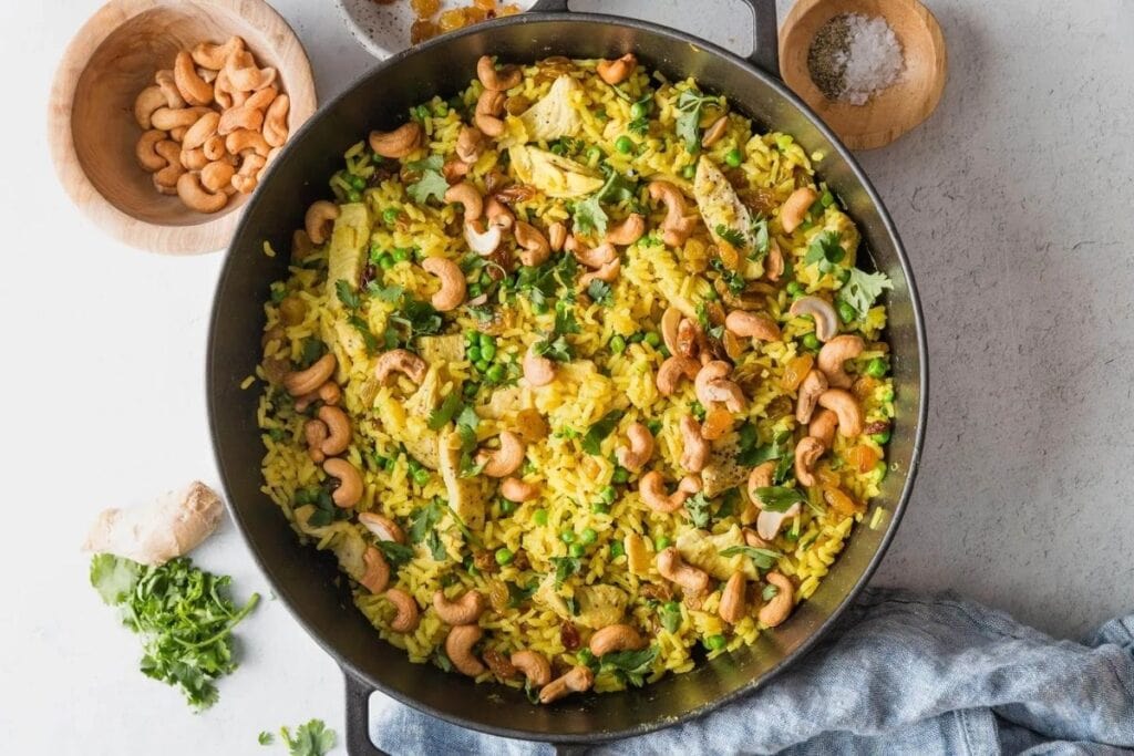 Curry cashew chicken and rice in a pan.