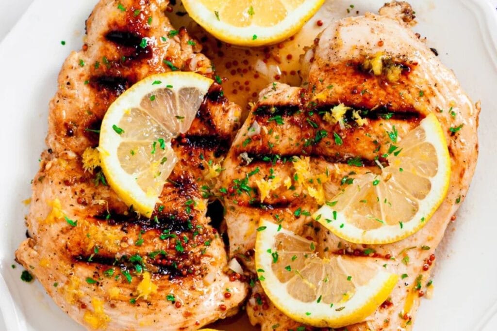 Grilled chicken with sliced lemons.