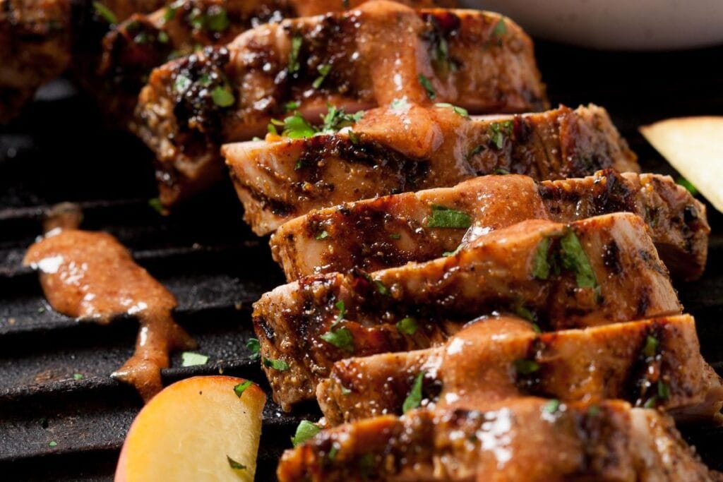 Sliced pork tenderloin on a griller.