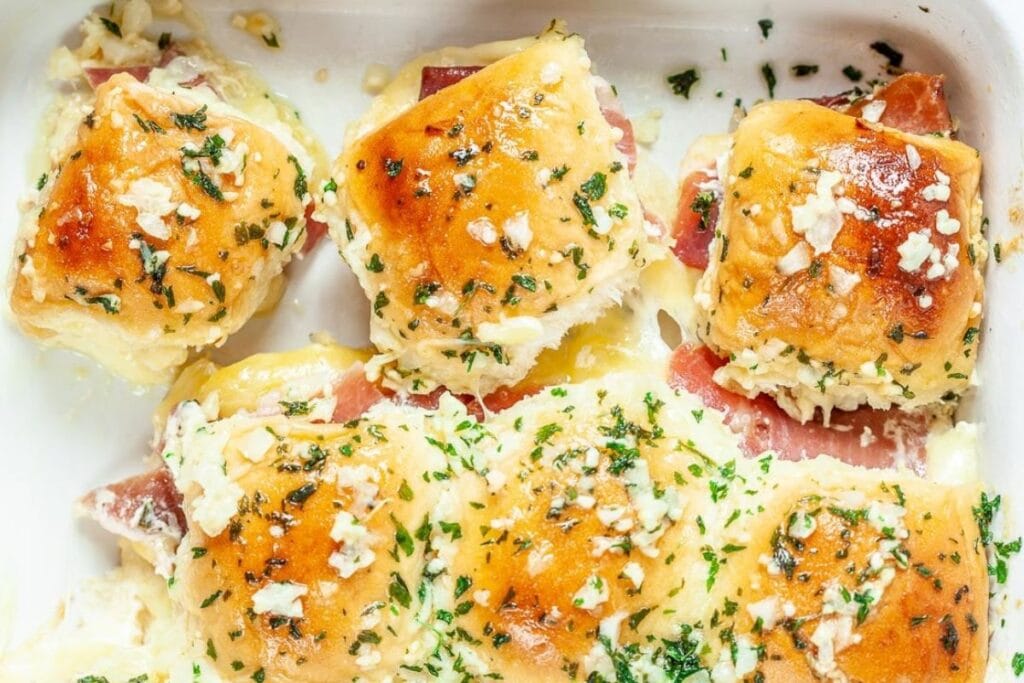 Ham and cheese sliders in a white dish.
