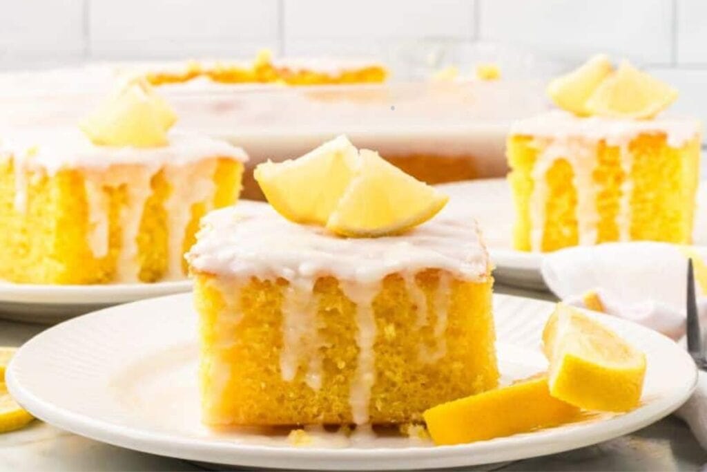 A slice of lemon poke cake on a plate.
