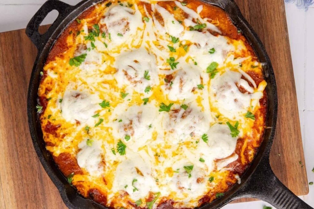 Meatball parmigiana in a pan.