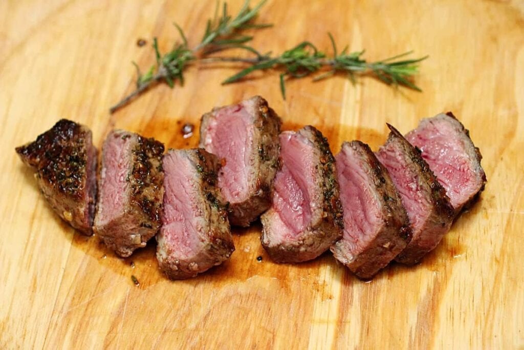 Sliced steaks on a wooden board.