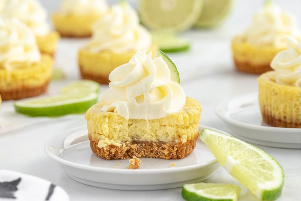 Mini Key Lime Pies on a white plate with whipped cream.