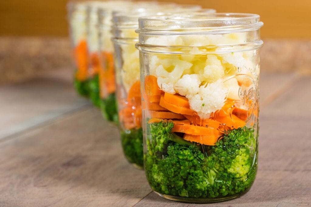 produce in mason jars on a wood counter
