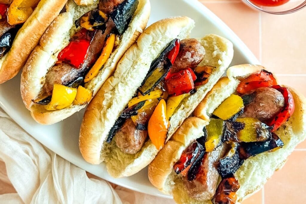 Sausage and peppers on white plate.