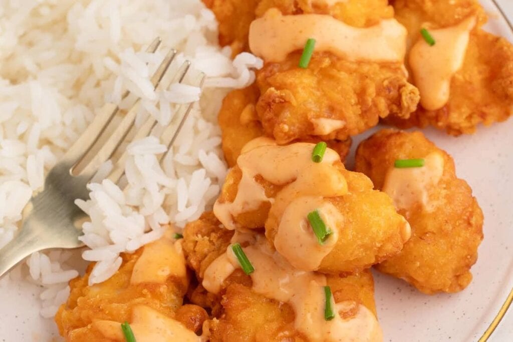 Chicken tenders with a creamy sauce and rice.