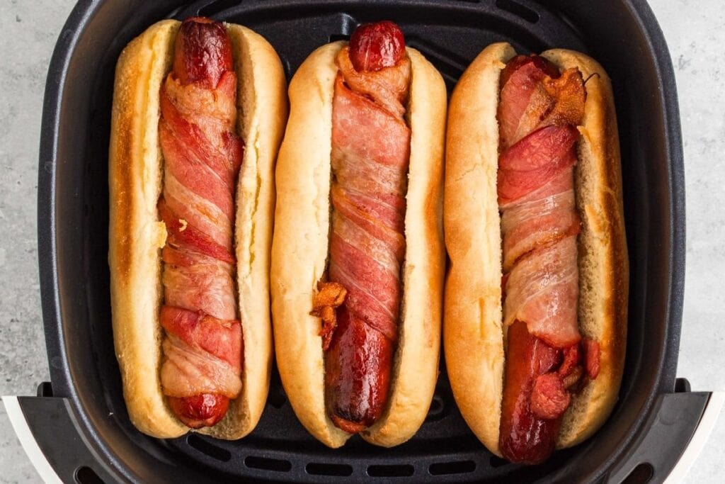 Hotdogs wrapped in bacon in air fryer.