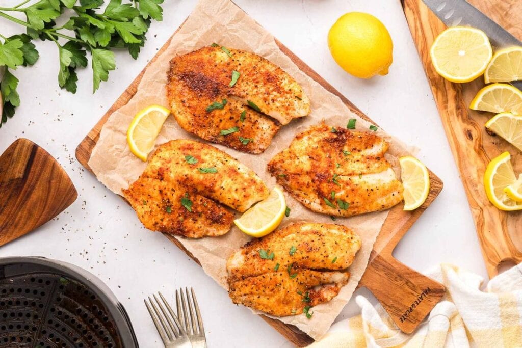 Fried tilapia on a wooden board.