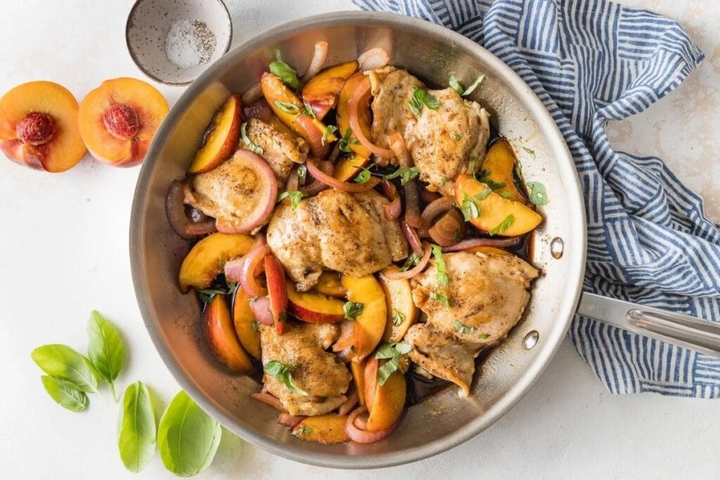 Chicken and peach in a pan.