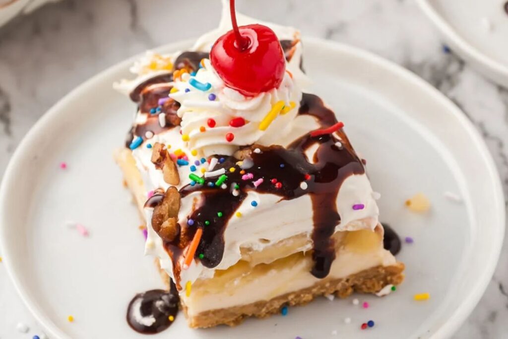 Banana split cake with cherry on top.