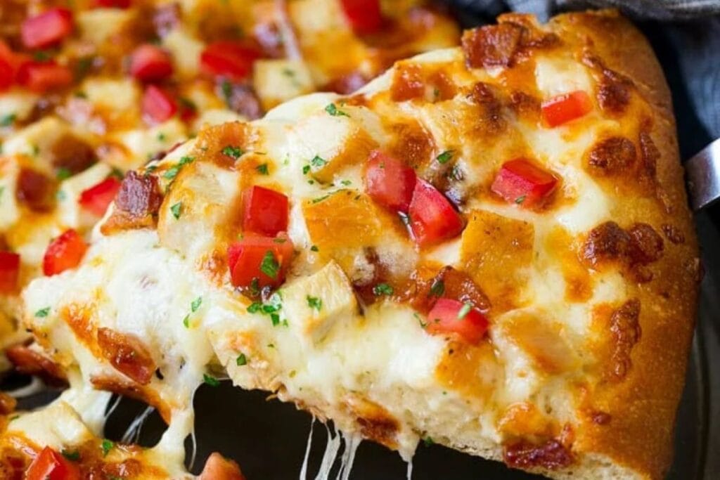 A slice of chicken alfredo pizza.