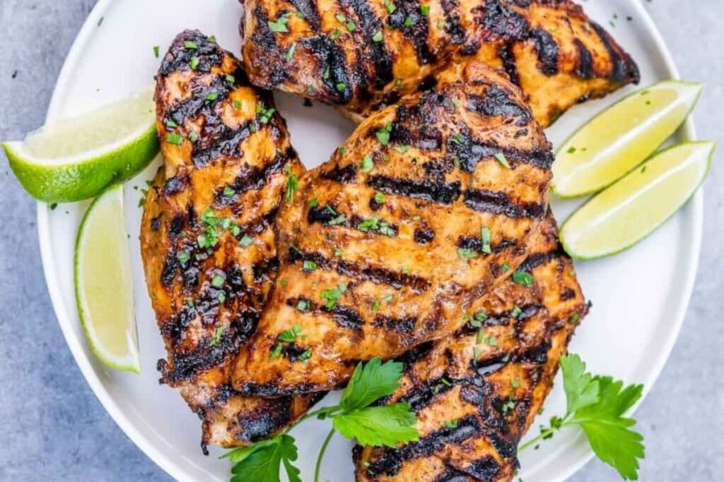 Grilled chicken with sliced limes.