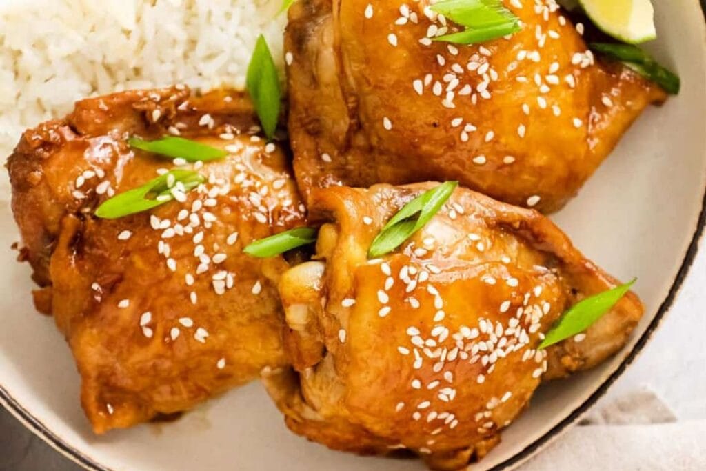 Three chicken thighs with sesame seeds.