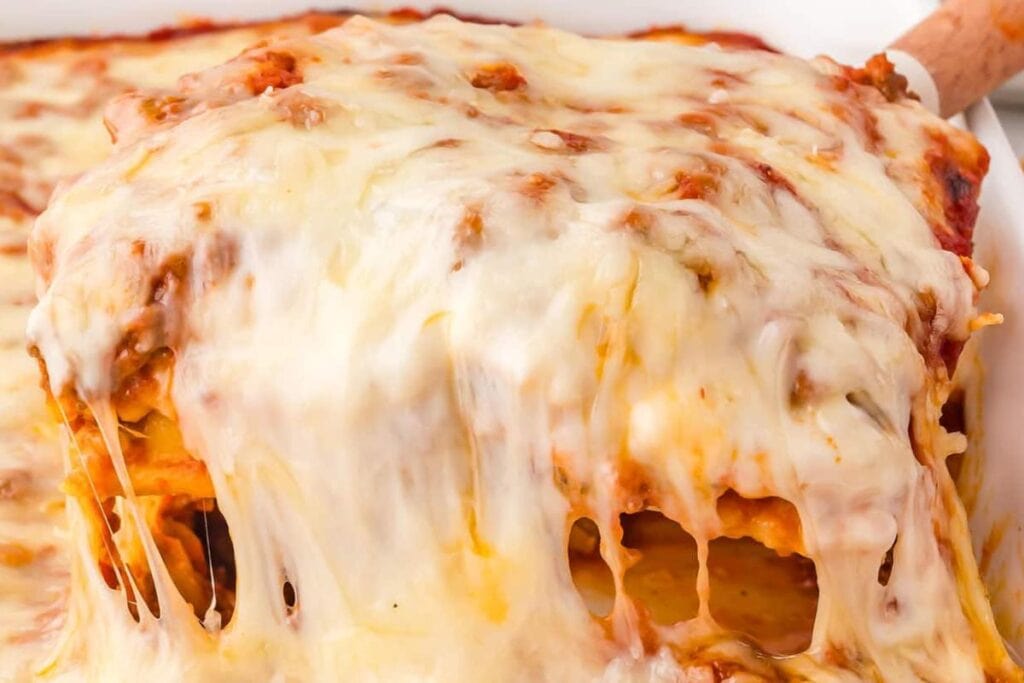 Cheesy lasagna in a white casserole dish.