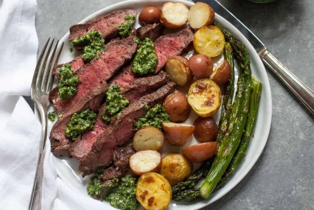 Steak and potatoes on a plate.