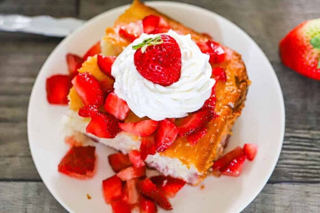 A slice of cake with strawberries on a plate.
