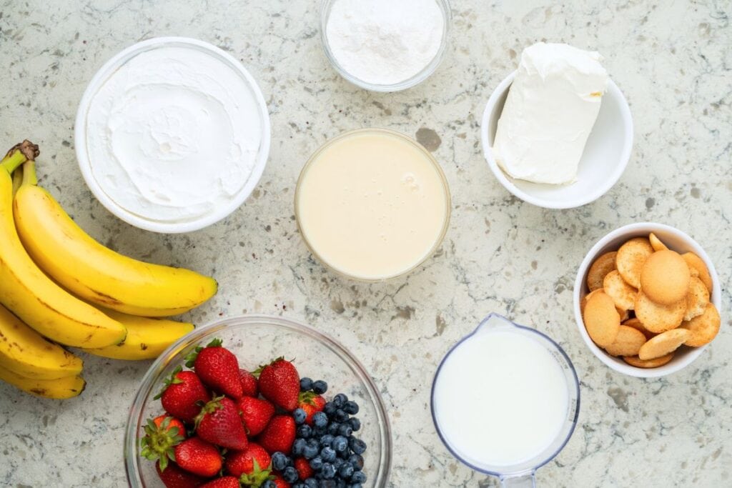 The ingredients for a flag icebox cake on marble background.