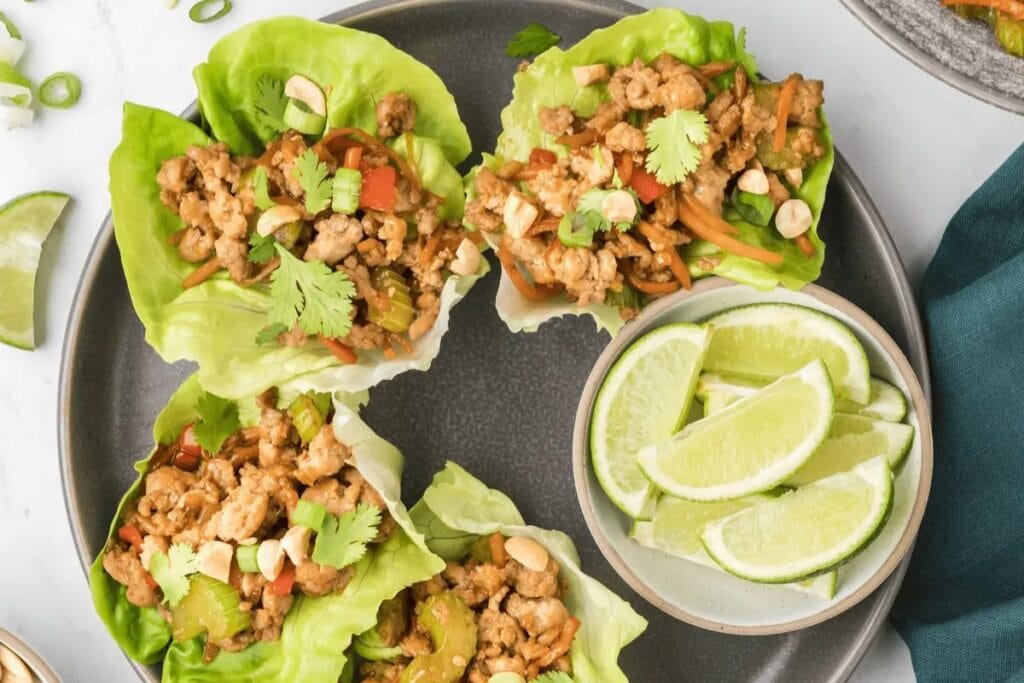 Chicken lettuce wraps on black plate.