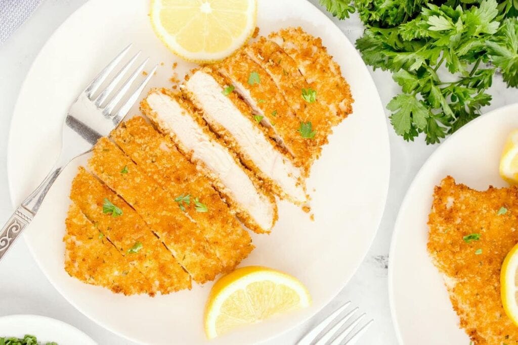 Sliced chicken cutlets on a plate.