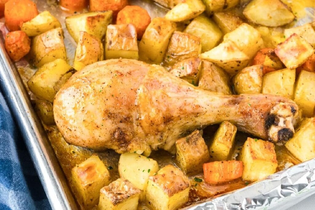Chicken drumstick with potatoes on a sheet pan. 
