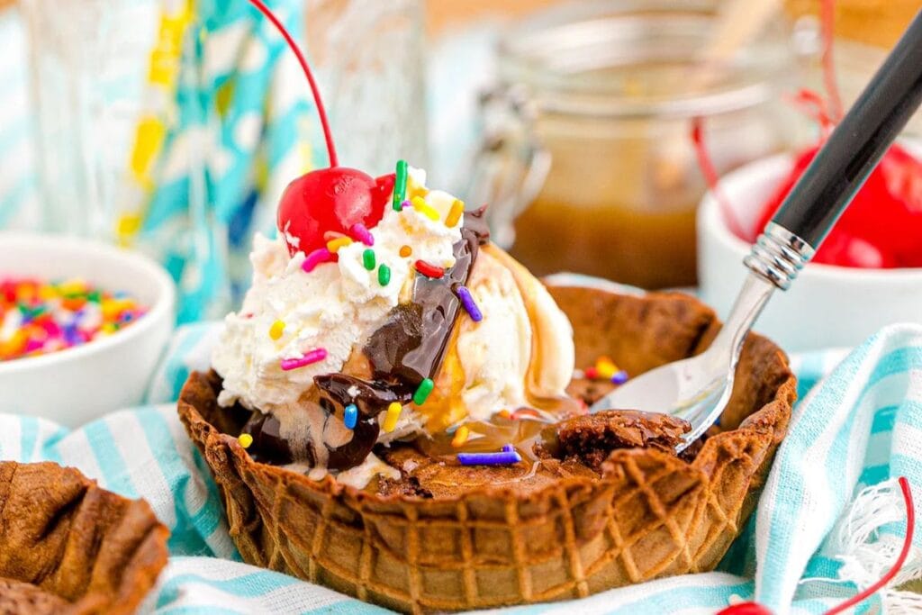 Brownie sundae waffle bowl with cherry on top.