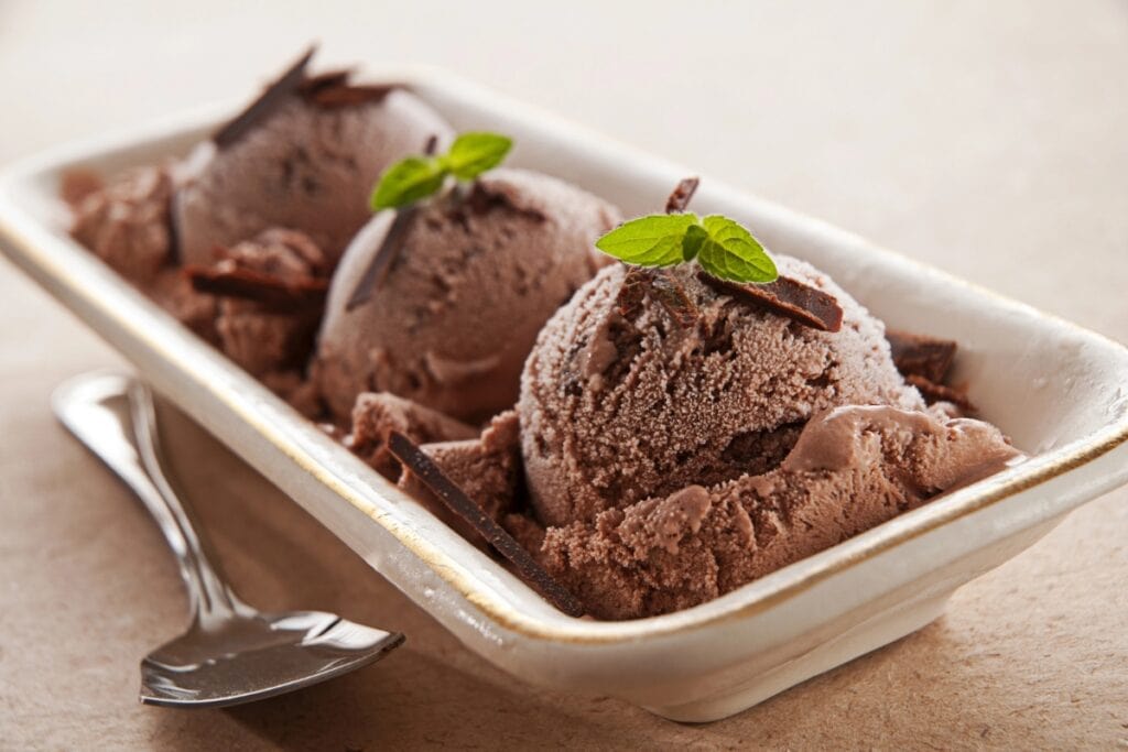 Chocolate ice cream topped with a mint leaf and shaved chocolate.