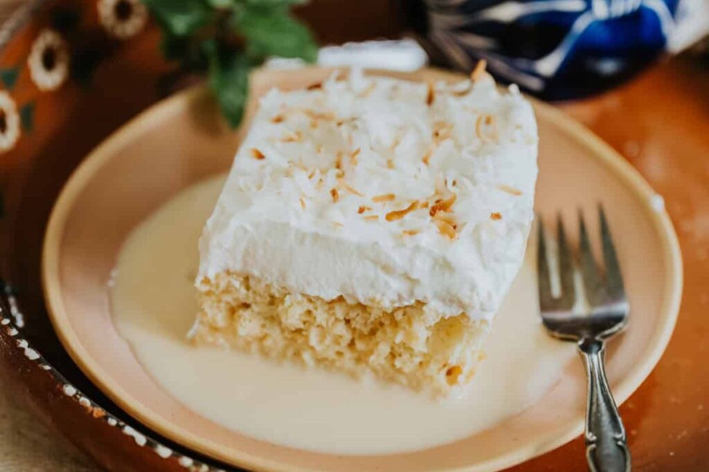 A slice of coconut cake on a plate.
