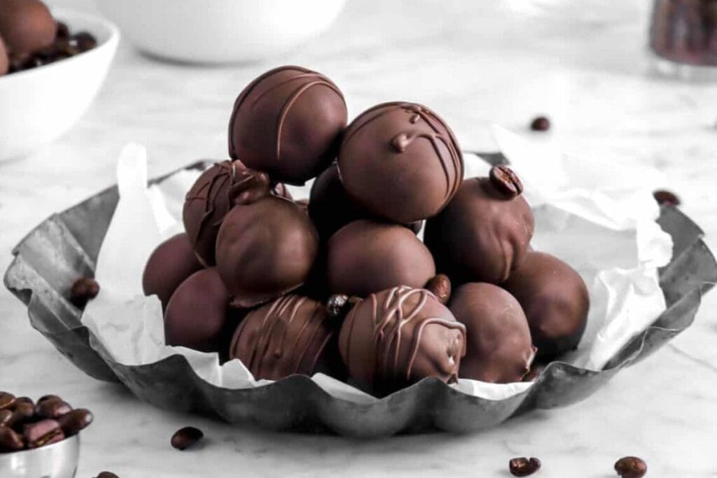 Dark chocolate coffee truffles on a plate.