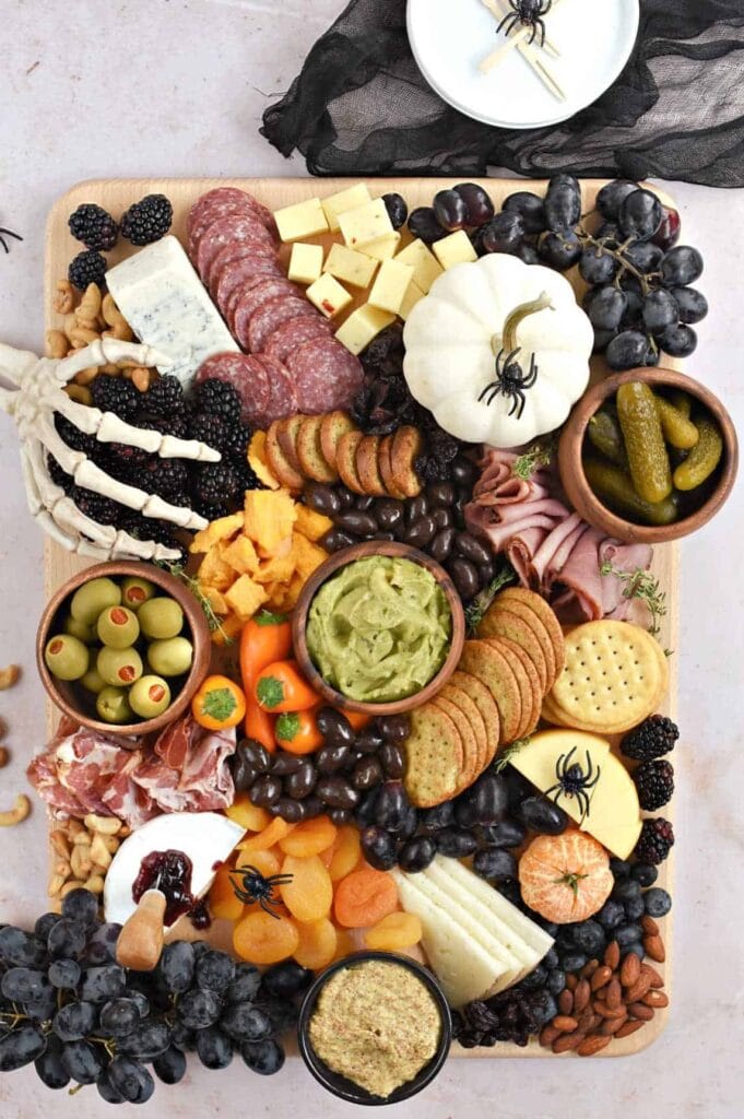 Charcuterie board with spooky decorations.