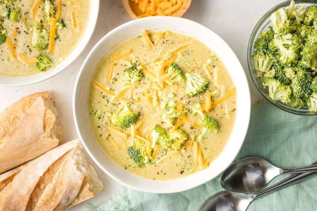 Two bowls of broccoli cheddar soups.