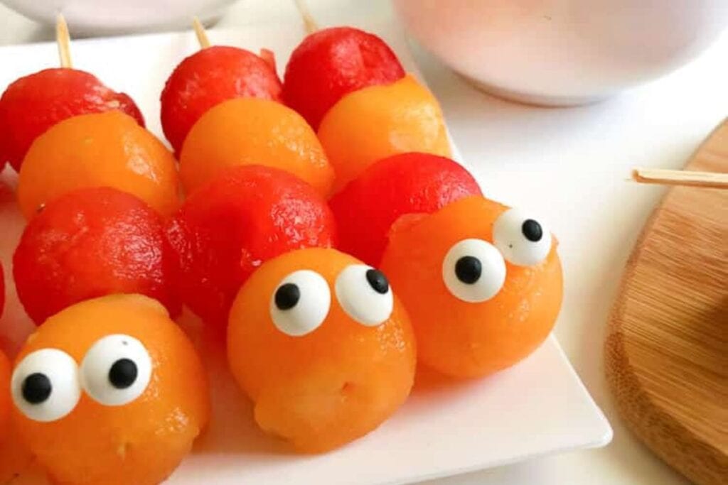 Melon kabobs on a plate.