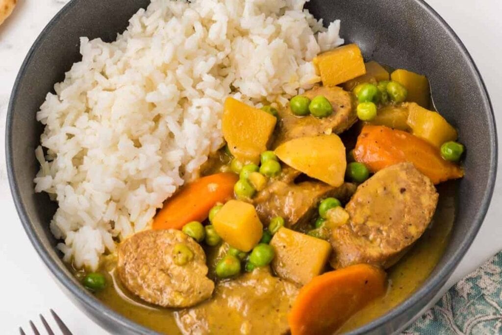 Rice and curried sausage in a bowl.