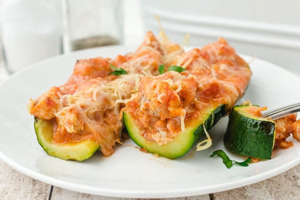 Stuffed zucchini boats on a plate.