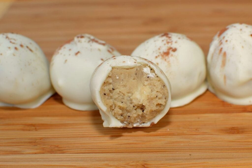Tiramisu truffles on a wooden surface.