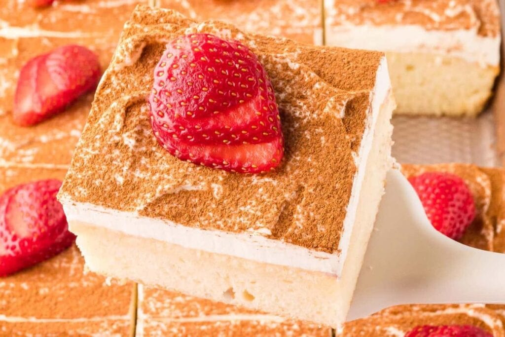 Tres leches cake with strawberries on top.