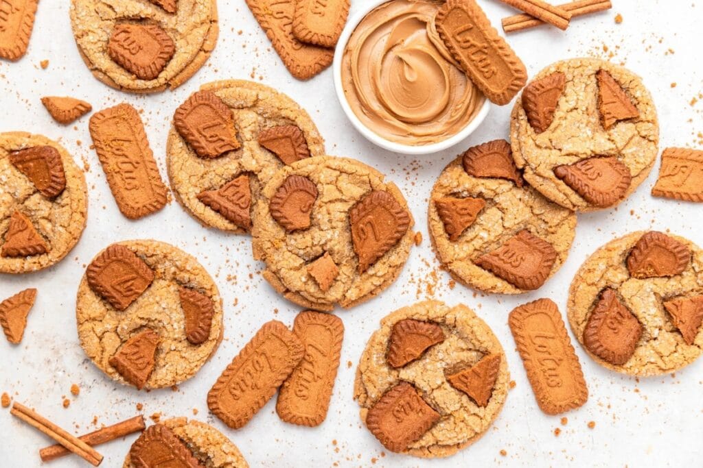 Biscoff butter cookies arranged on parchment paper with a side of peanut butter dip.