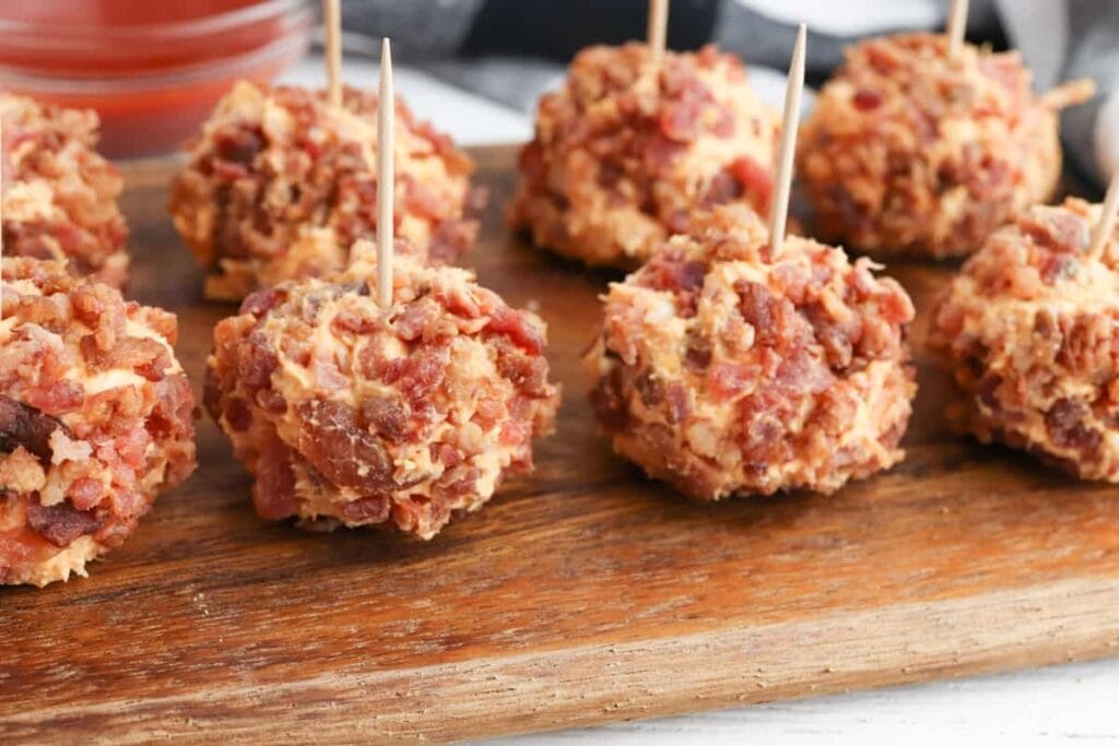 Buffalo chicken cheese balls on a wooden board.