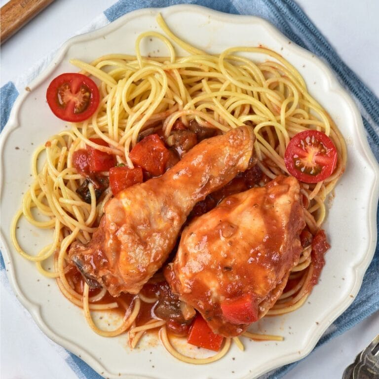 Chicken Cacciatore with pasta on a white plate.