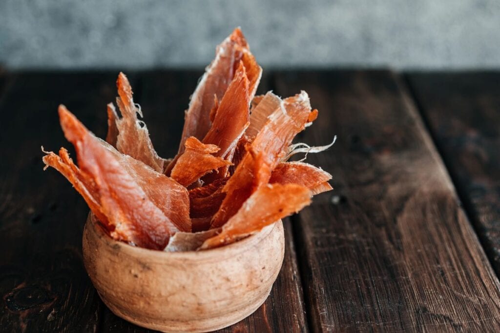 Chicken jerky dog treat in bowl.