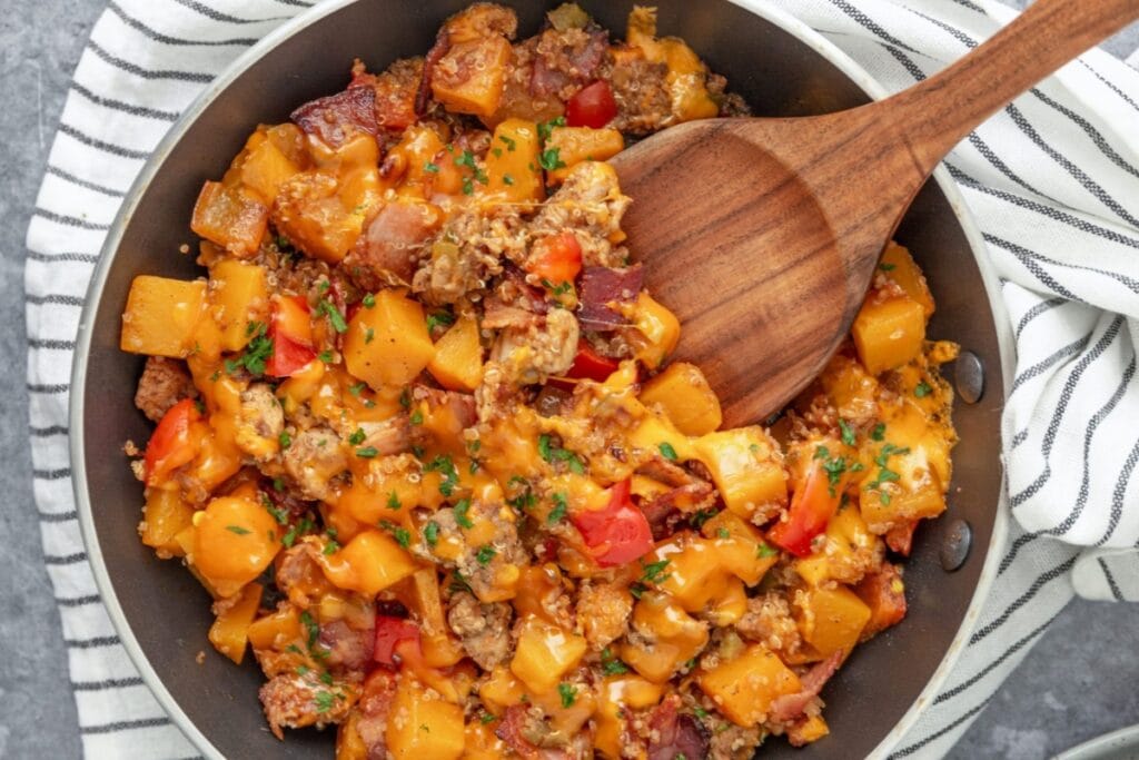 Chicken, quinoa, and sweet potatoes in a skillet.