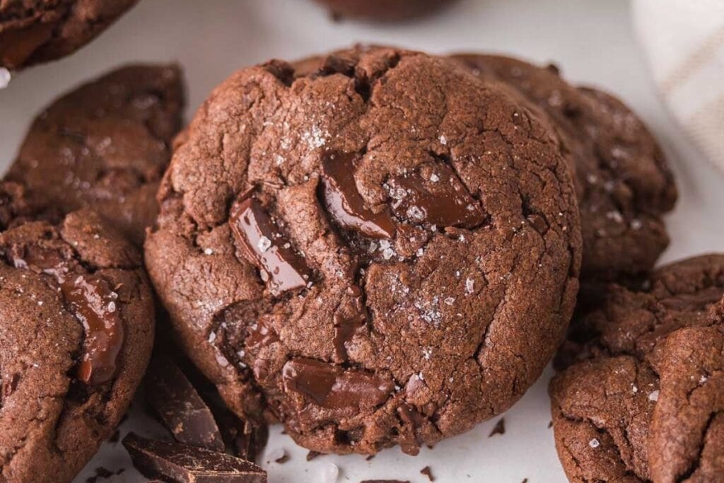 Chocolate fudge cookies resting on parchment paper.