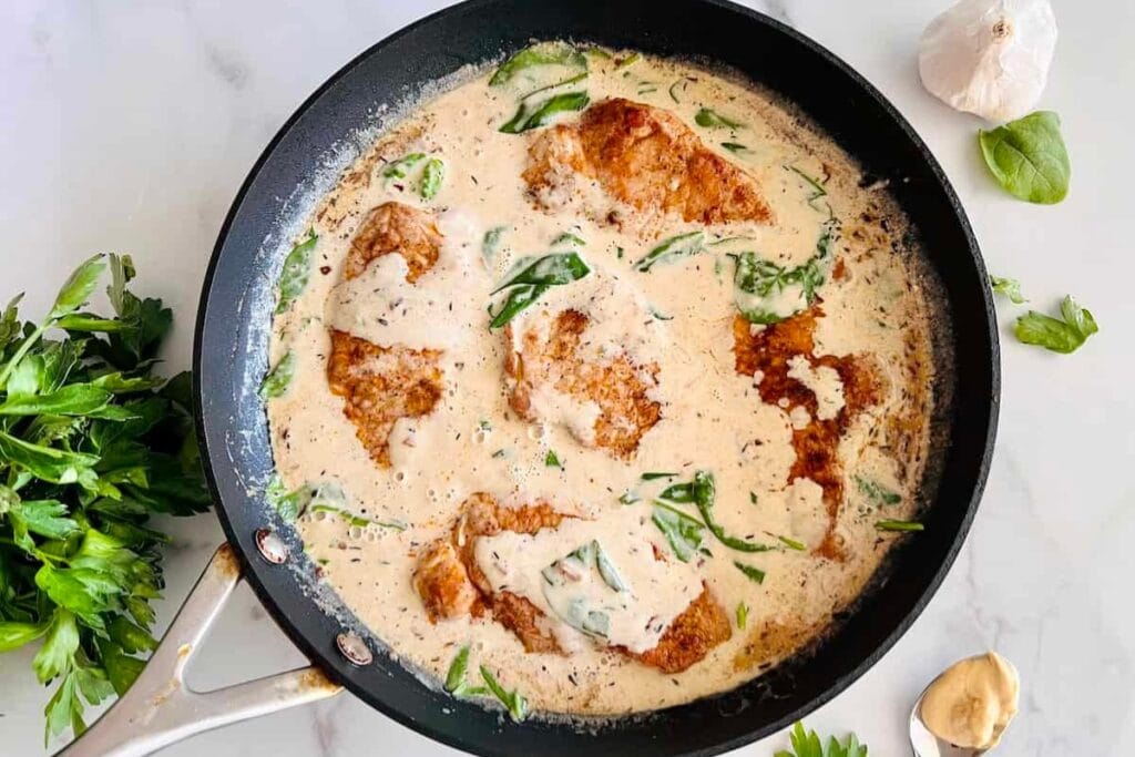 Creamy Dijon pork chops in a cooking pot.