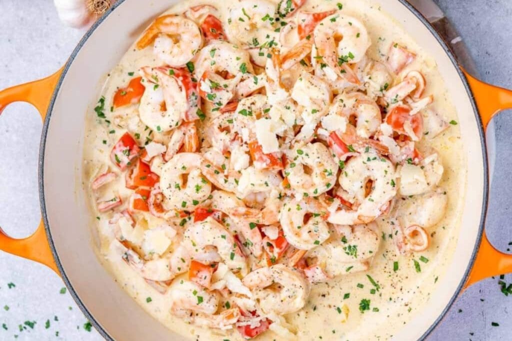 Shrimp cooked in a skillet with creamy garlic sauce.