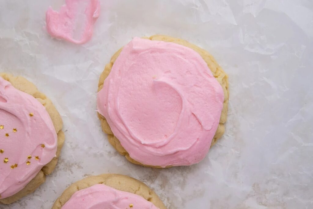 Crumbl sugar cookies on parchment paper.
