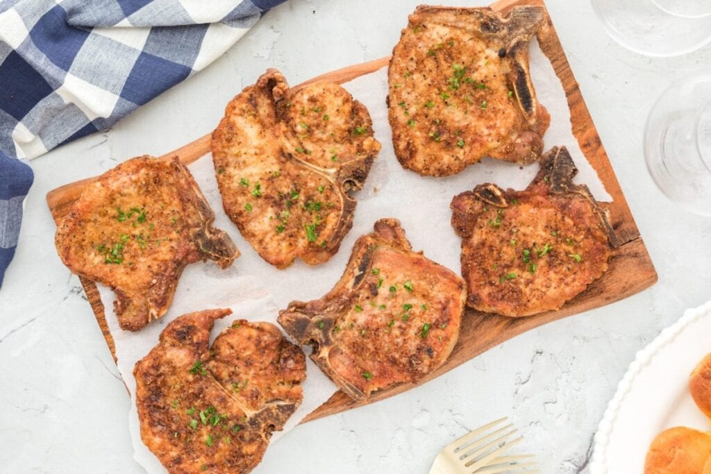 Fried pork chops on a wooden board.