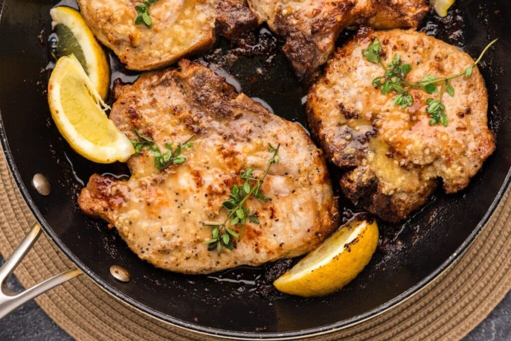 Close-up of garlic butter pork chops cooked in a skillet.